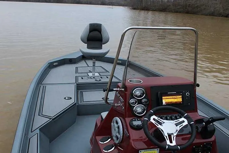 Slide: The Image of 2026 Excel 220 Bay Pro Elite boat on calm water, featuring modern dashboard and seating. - 8