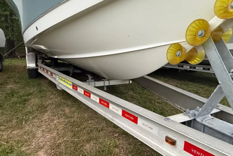 Slide: The Image of 2021 Sea Hunt Ultra 275 SE boat on a Venture trailer, parked on grass. - 19