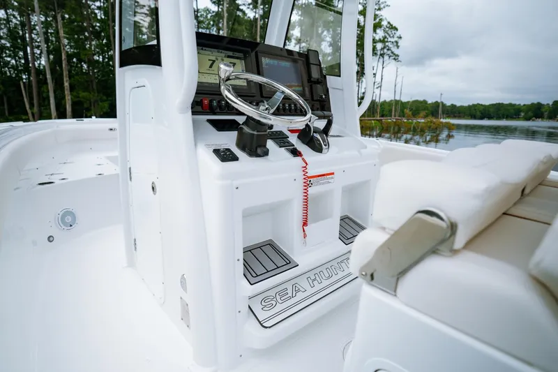 Slide: The Image of 2021 Sea Hunt Ultra 275 SE boat with covered console, docked outdoors. - 9