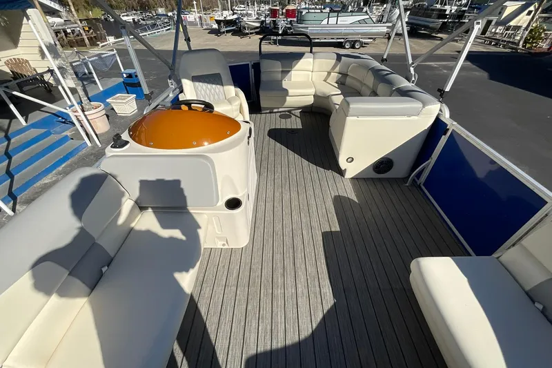 Slide: The Image of 2021 Lexington 318 3 Series pontoon boat interior with beige seating and wood flooring. - 10