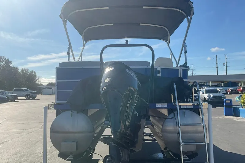 Slide: The Image of 2021 Lexington 318 3 Series pontoon boat with outboard motor in a parking lot. - 7