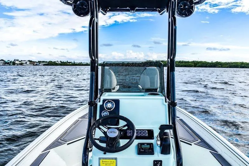 Slide: The Image of 2026 Excel 230 Bay Pro Elite boat on open water, featuring modern steering console. - 7