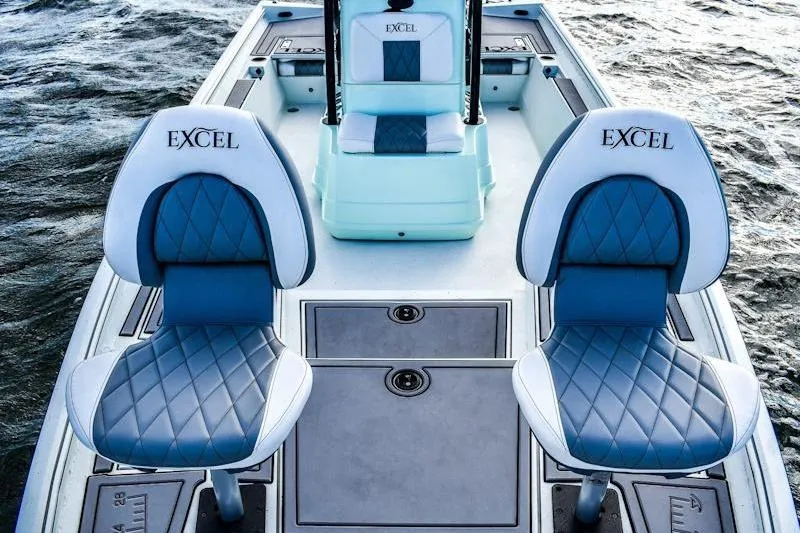 Slide: The Image of 2026 Excel 230 Bay Pro Elite boat with stylish blue and white seating on water. - 9