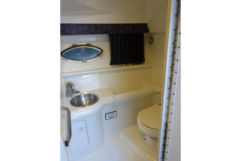 Slide: The Image of 2002 Formula 330 Sun Sport boat bathroom with sink, toilet, and oval window. - 15