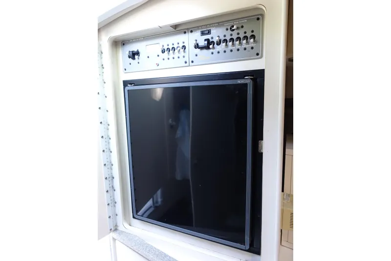 Slide: The Image of Control panel and refrigerator in 2002 Formula 330 Sun Sport boat interior. - 19