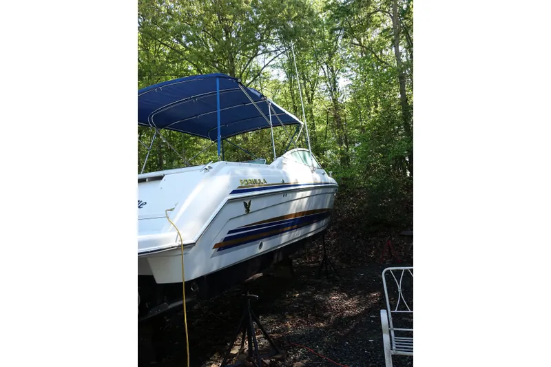 Slide: The Image of 2002 Formula 330 Sun Sport boat with blue canopy, parked in wooded area. - 3