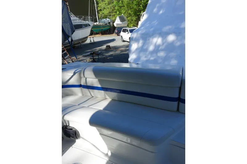 Slide: The Image of 2002 Formula 330 Sun Sport boat interior with white and blue seating in a marina. - 7