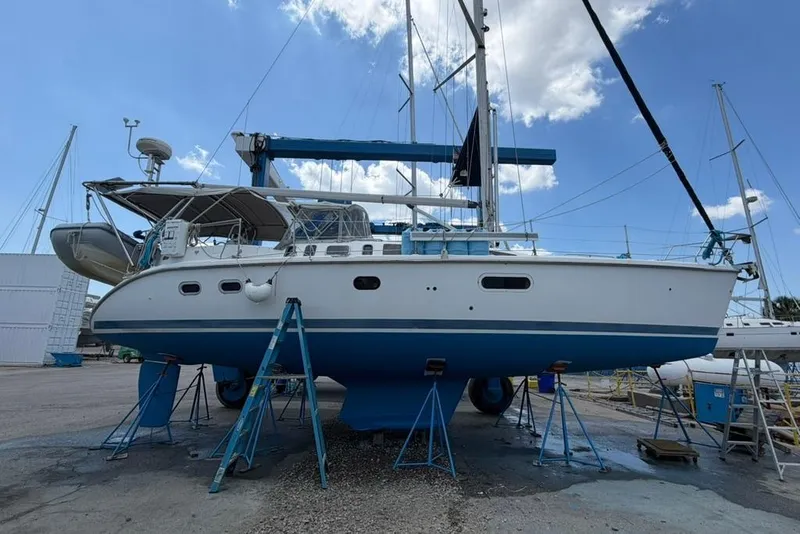 Slide: The Image of Sailboat Hunter 410, 2002 model, on stands in a boatyard under a blue sky. - 11