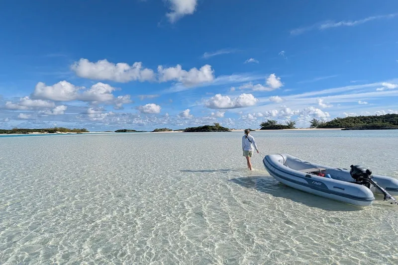 Slide: The Image of Person with inflatable boat on clear shallow water under blue sky. - 17