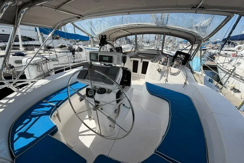 Slide: The Image of Spacious cockpit of a 2002 Hunter 410 sailboat with blue cushions and steering wheel. - 18