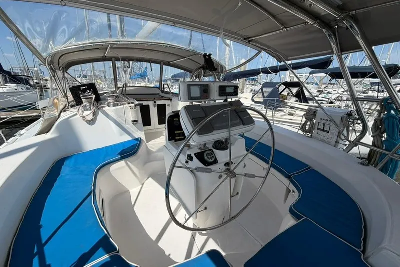 Slide: The Image of Interior view of a 2002 Hunter 410 sailboat cockpit with blue seating and navigation equipment. - 20