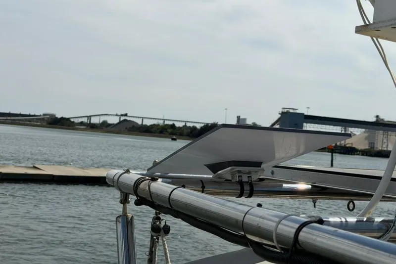 Slide: The Image of Hunter 410 sailboat, 2002 model, docked by industrial waterfront with clear sky. - 26