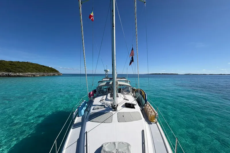 Slide: The Image of Sailboat on clear turquoise waters, Hunter 410 model, 2002, with flags and scenic island view. - 3