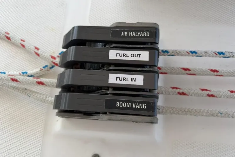 Slide: The Image of Sailing rope clutches labeled "Jib Halyard," "Furl Out," "Furl In," and "Boom Vang" on a Hunter 410. - 31