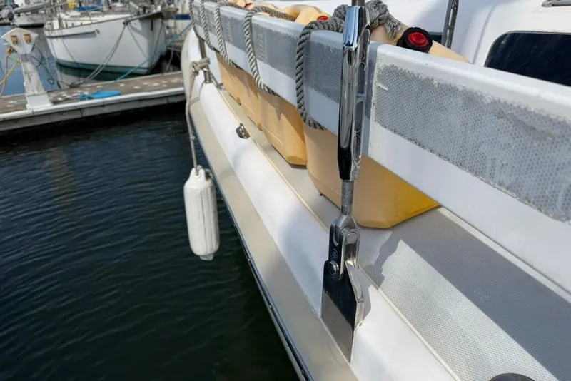 Slide: The Image of Side view of a 2002 Hunter 410 sailboat docked, showing fender and railing details. - 33