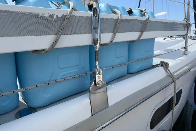 Slide: The Image of Blue jerry cans secured on a 2002 Hunter 410 sailboat deck with ropes. - 35