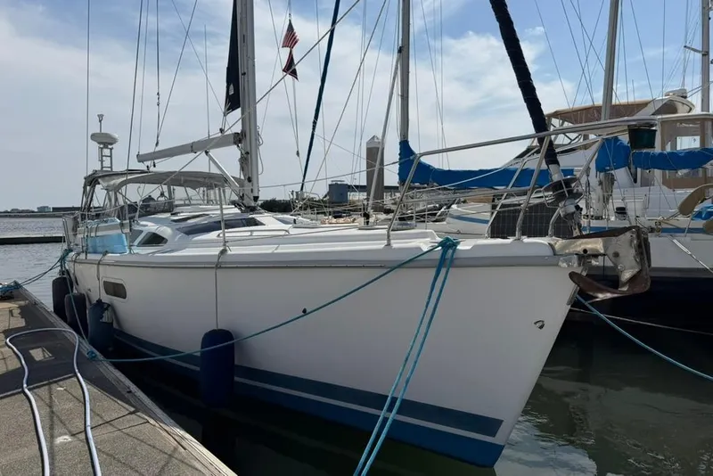 Slide: The Image of 2002 Hunter 410 sailboat docked at marina, featuring sleek design and blue accents. - 4
