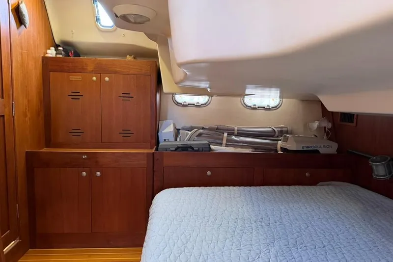 Slide: The Image of Cozy cabin interior of a 2002 Hunter 410 sailboat with wooden cabinetry and bed. - 46