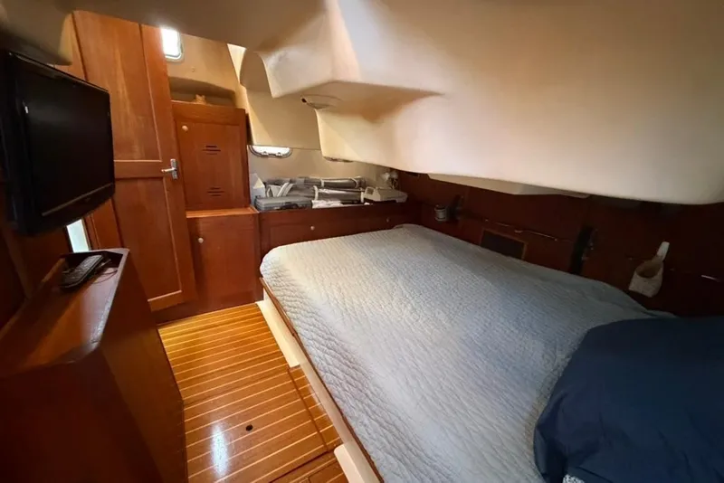 Slide: The Image of Cozy cabin interior of 2002 Hunter 410 sailboat with wooden furnishings and a comfortable bed. - 47