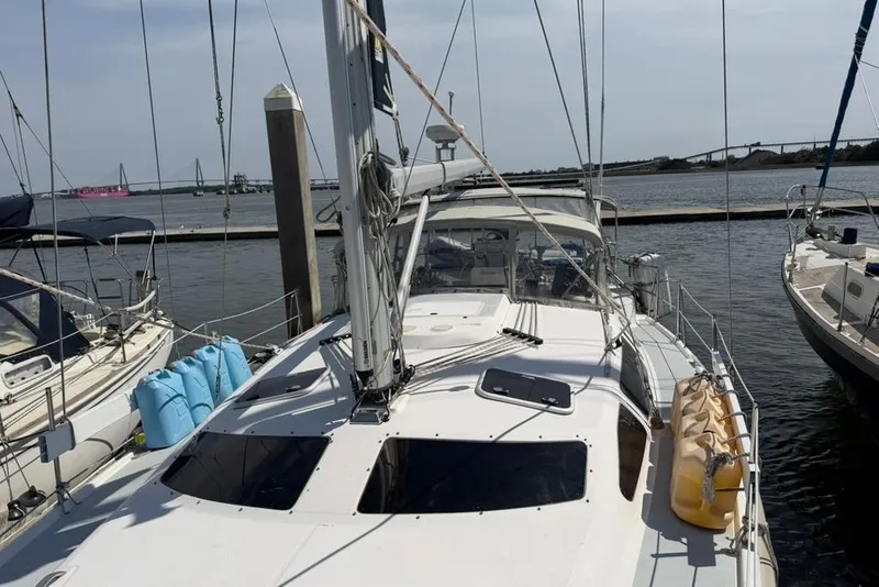Slide: The Image of 2002 Hunter 410 sailboat docked at marina, surrounded by other boats. - 5