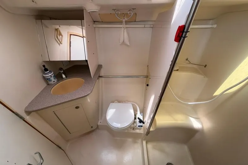 Slide: The Image of Compact bathroom in a 2002 Hunter 410 yacht, featuring a sink, toilet, and shower. - 50