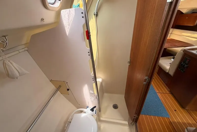Slide: The Image of Interior of a 2002 Hunter 410 sailboat bathroom with shower and wooden door. - 52
