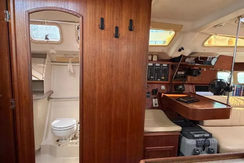 Slide: The Image of Interior of a 2002 Hunter 410 sailboat featuring a bathroom and navigation station. - 54