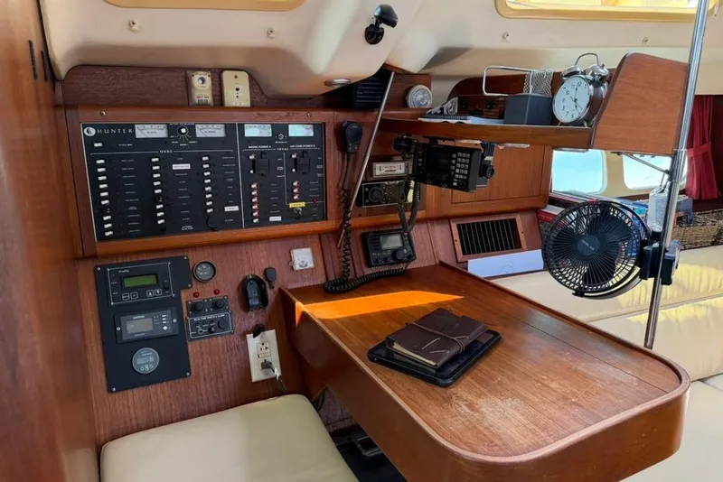 Slide: The Image of Navigation station of a 2002 Hunter 410 sailboat with control panels and equipment. - 58