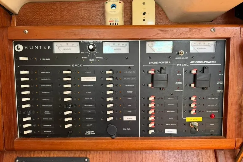 Slide: The Image of Electrical control panel of a 2002 Hunter 410 yacht, featuring various switches and meters. - 59