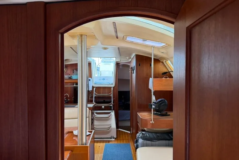 Slide: The Image of Interior view of 2002 Hunter 410 sailboat with wooden finishes and seating area. - 60