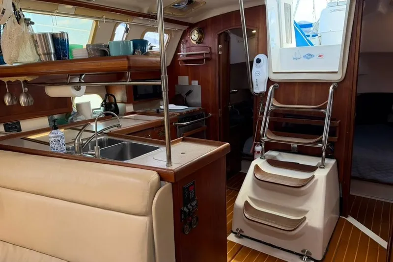 Slide: The Image of Interior of a 2002 Hunter 410 sailboat featuring a cozy kitchen and wooden accents. - 61