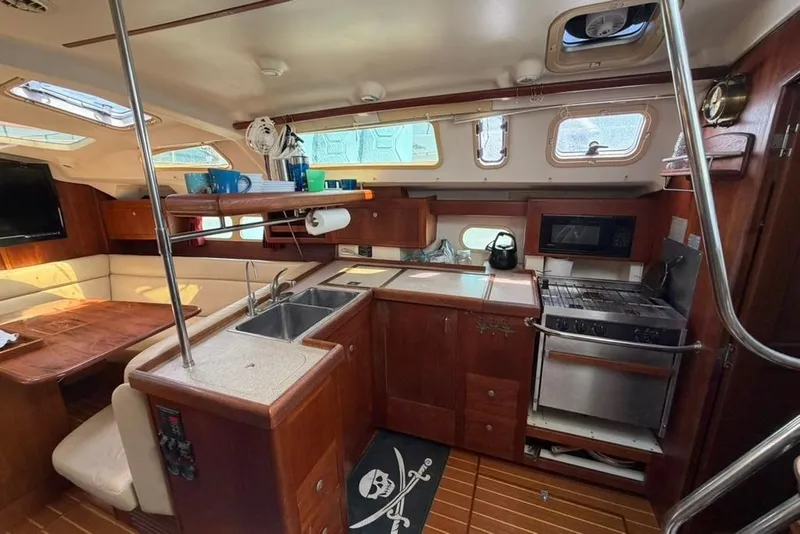 Slide: The Image of Interior of a 2002 Hunter 410 sailboat featuring a cozy kitchen and dining area. - 65