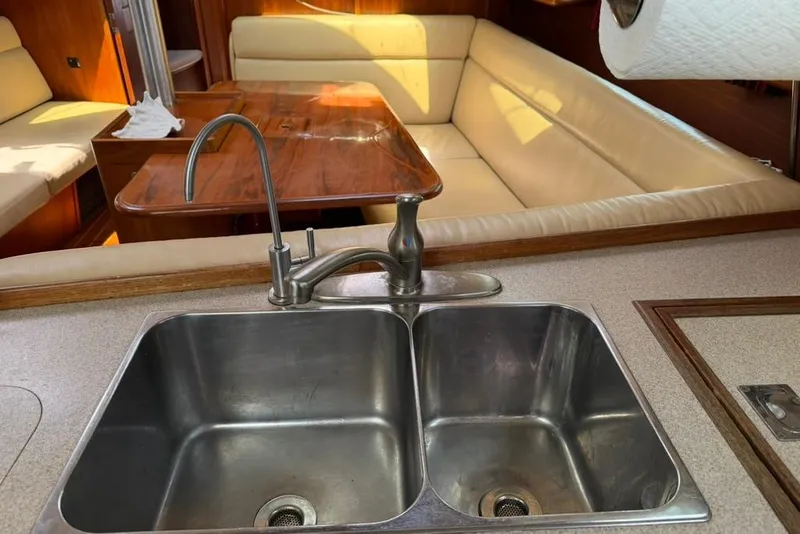 Slide: The Image of Kitchen sink and dining area in a 2002 Hunter 410 yacht interior. - 67