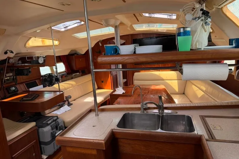 Slide: The Image of Interior of a 2002 Hunter 410 sailboat featuring a cozy seating area and kitchen. - 68