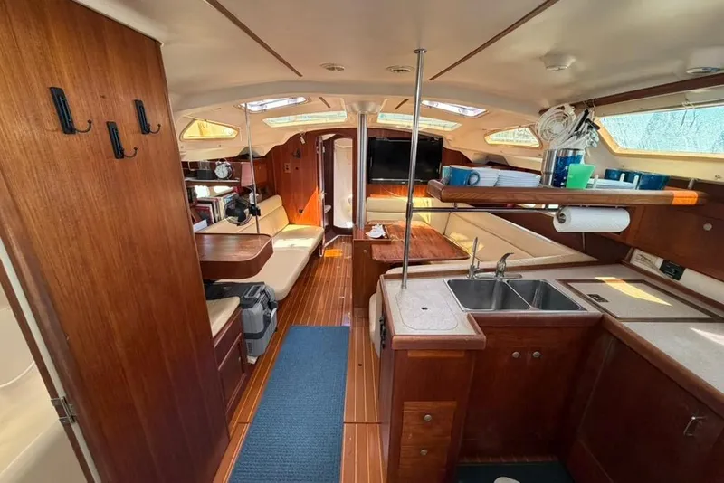 Slide: The Image of Interior of a 2002 Hunter 410 sailboat with wooden furnishings and modern amenities. - 70