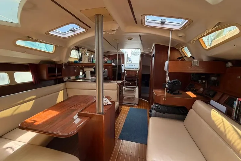 Slide: The Image of Interior of a 2002 Hunter 410 sailboat with wooden furnishings and ample seating. - 72