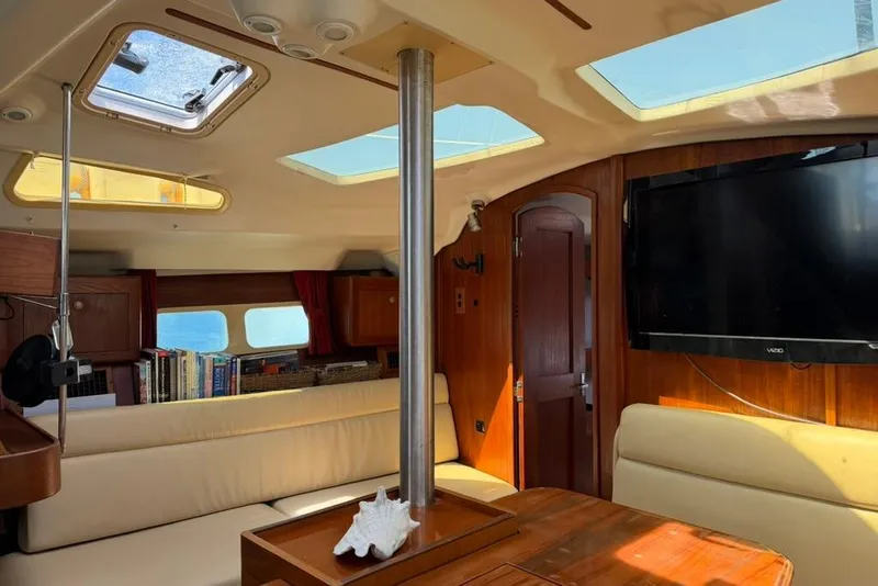 Slide: The Image of Interior of a 2002 Hunter 410 sailboat with skylights, seating, and a TV. - 73