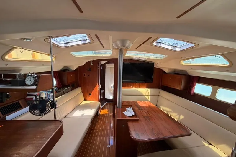 Slide: The Image of Interior of a 2002 Hunter 410 sailboat with elegant wood finish and ample seating. - 76