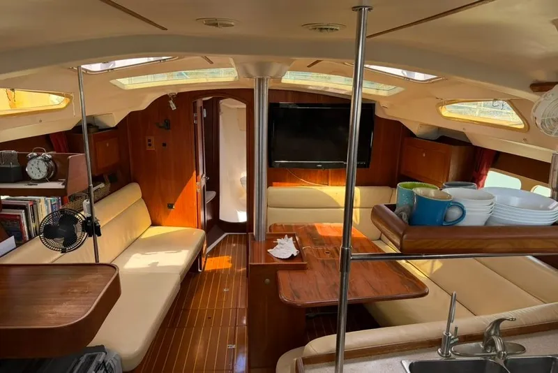 Slide: The Image of Interior of a 2002 Hunter 410 sailboat with cozy seating and wooden finishes. - 77