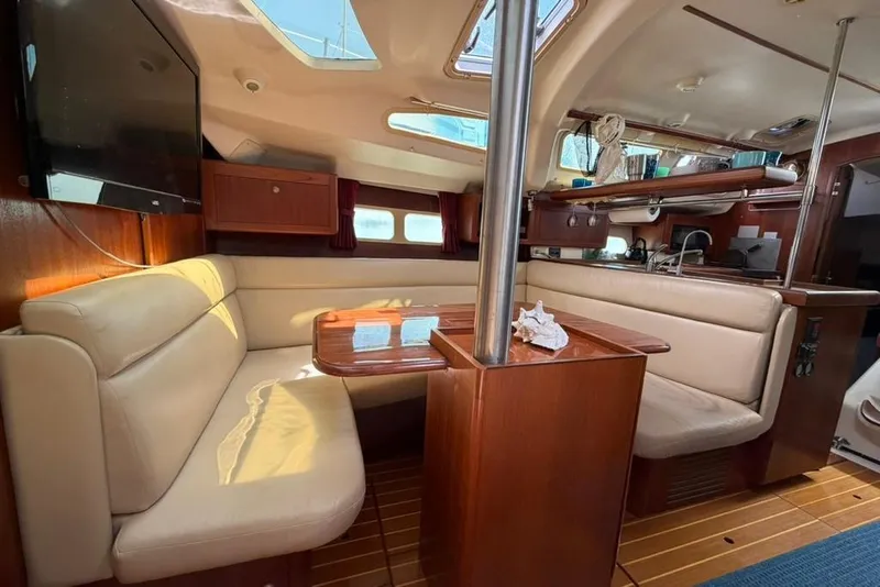 Slide: The Image of Interior of a 2002 Hunter 410 sailboat with cozy seating and wooden finishes. - 78