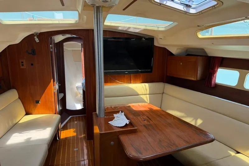 Slide: The Image of Interior of a 2002 Hunter 410 sailboat with wood finish and seating area. - 79
