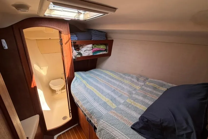 Slide: The Image of Cozy cabin interior of 2002 Hunter 410 sailboat with bed and compact bathroom. - 80