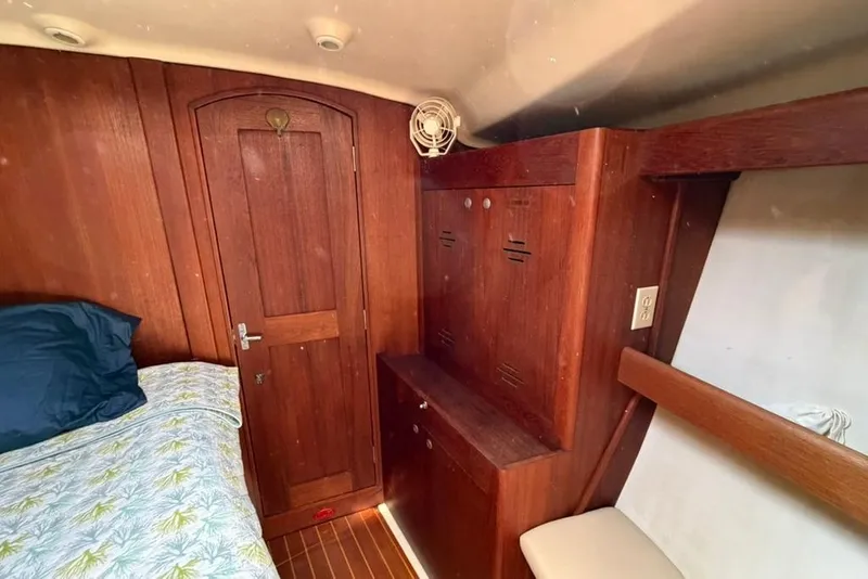 Slide: The Image of Interior of 2002 Hunter 410 sailboat cabin with wooden furnishings and bedding. - 81