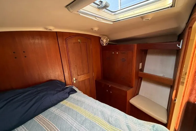 Slide: The Image of Cozy cabin interior of 2002 Hunter 410 sailboat with wooden furnishings and skylight. - 82