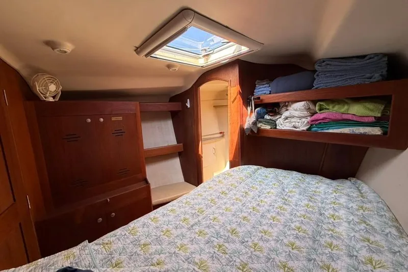 Slide: The Image of Cozy cabin interior of 2002 Hunter 410 sailboat with bed, skylight, and storage shelves. - 83