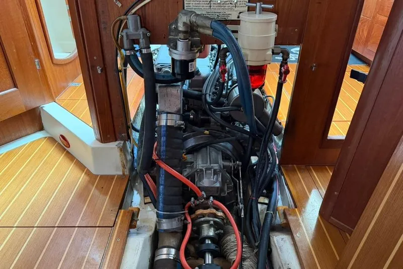 Slide: The Image of Engine compartment of a 2002 Hunter 410 sailboat with visible components and wooden flooring. - 87