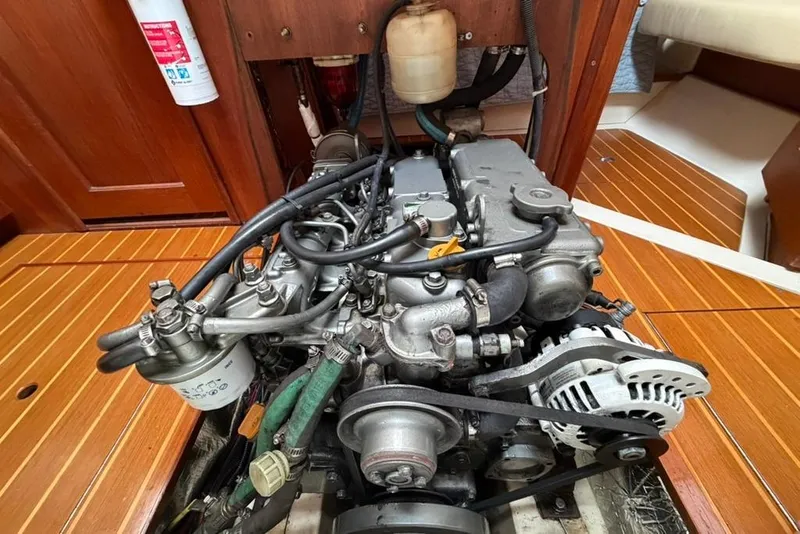 Slide: The Image of Engine of a 2002 Hunter 410 sailboat, showcasing mechanical components and wooden flooring. - 88