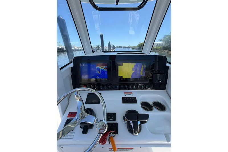 Slide: The Image of 2021 Sea Hunt Gamefish 27 Coffin Box helm with navigation screens and steering wheel. - 13