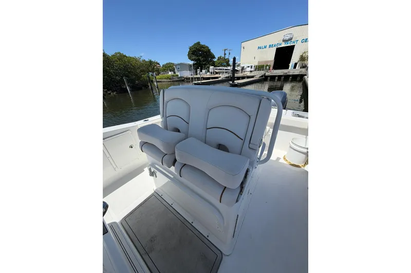 Slide: The Image of 2021 Sea Hunt Gamefish 27 Coffin Box boat interior with cushioned seating at dock. - 15