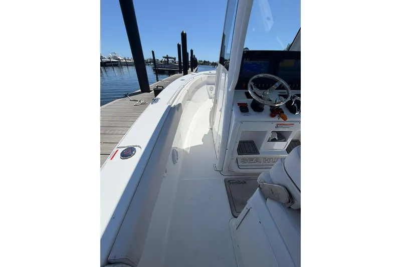 Slide: The Image of 2021 Sea Hunt Gamefish 27 Coffin Box boat interior at dock, featuring helm and seating. - 16